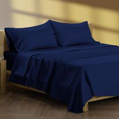 a bed with blue sheets and pillows on it