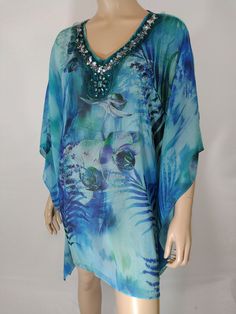 "Boho Tunic Top Women's Butterfly Sleeve  Wild Abstract Semi Sheer Chic Excellent  Condition Vintage Size 1X by NEW DIRECTION WOMAN Cool, chic, boho. Blue shades make up this wild abstract floral print, gorgeous heavily beaded neckline, butterfly sleeve, Gorgeous light textured semi sheer fabric, great details. Super high quality. Expensive lux...purchased from SOUTH FLORIDA MIAMI boutique. Excellent condition. Can be worn with or without belt and does not come with belt. Easy to wear casual chic vintage for the disco sporting life. MEASUREMENTS: Length- 31\" Bust (underarms to underarms)  25\"x2 Sleeve (shoulder to cuff) 12\" Waist - 25\"x2 Hips - 26\"x2 MODEL STATS: Ht. - 5' 8.5\" Bust - 34\" Waist - 25\" Hips - 35\" *Please check measurements to ensure proper fit and remember to allow e Blue Embellished V-neck Top, Embellished Blue V-neck Top, Blue Bohemian Beaded Top, Bohemian Blue Beaded Top, Bohemian Beaded Blue Top, Carrie White, Plus Size Tunic, Boho Beach Dress, Boho Tunic Tops