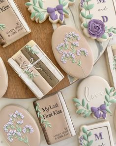 cookies decorated with flowers and names are arranged on a table next to some personal items