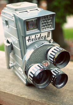 an old camera sitting on top of a wooden table