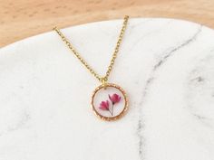 Silver Listing - https://www.etsy.com/uk/listing/1510947161 This little textured necklace features some real little Japanese Blossom flowers which are encapsulated in a clear resin. This is a simple yet beautiful necklace which would make the perfect birthday or bridesmaid gifts. Pink Flower Jewellery, Japanese Blossom, Bridesmaid Necklace Gift, Jewellery For Women, Round Necklace, Rose Jewelry, Bridesmaid Necklace, Clear Resin, Blossom Flower