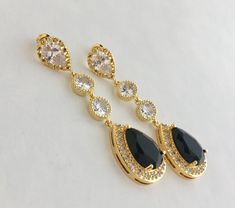 I've created these absolutely gorgeous super sparkly long black crystal earrings in gold plated brass setting. Earrings feature a large teardrop with pear cut black cubic zirconia center surrounded by tiny round zirconia crystals. Teardrop dangles from a bright cubic zirconia ear stud and two round cubic zirconia connectors. Total length of the earrings is 6 cms. For matching necklace click: https://www.etsy.com/listing/763689760/black-bridal-necklace-black-gold-crystal?ref=shop_home_active_2 Fo Elegant Gold Earrings With Black Diamonds, Glamorous Black Crystal Earrings For Wedding, Black Wedding Jewelry, Black Gold Earrings, Black Crystal Earrings, Pink Pearl Earrings, Black Bridesmaid, Black Bridesmaids, Black Gold Jewelry