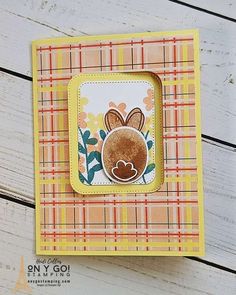 a close up of a card with a bunny on it's face and plaid background