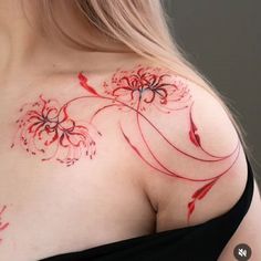 a woman's shoulder with red ink on it and flowers painted on the chest