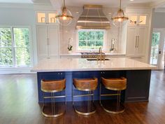 a kitchen island with three stools next to it