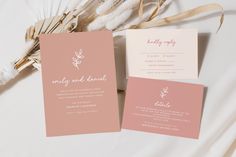 two pink and white wedding cards on top of each other next to some dried flowers