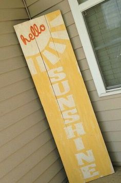 a wooden sign that says hello sunshine on the side of a house in front of a window