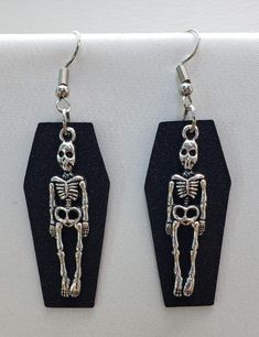 A cute light weight earring for Halloween!   These earrings feature a silver skeleton charm backed by a shimmer black or red coffin,  The ear wires are nickel-free silver. Clay Coffin Earrings, Silver Skull Earrings For Halloween, Edgy Adjustable Earrings For Halloween, Nickel Free Black Skull Earrings, Spooky Black Nickel-free Jewelry, Vampire Style Metal Earrings For Halloween, Edgy Silver Earrings For Halloween, Halloween Vampire Metal Earrings, Edgy Sterling Silver Jewelry For Halloween