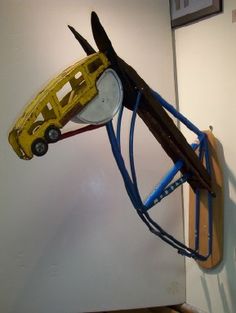 a yellow toy car is attached to a wall with wires connected to it and hanging from the ceiling