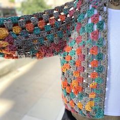 a crocheted granny shawl hanging from a mannequin's torso