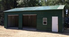 a green garage with two doors and windows