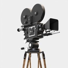 an old fashioned movie camera sitting on top of a wooden tripod in front of a white background