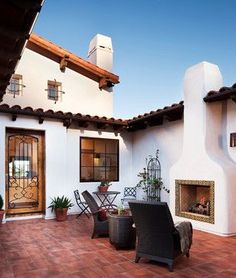 an outdoor patio with chairs, table and fire place