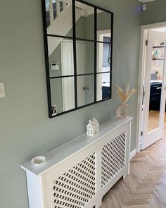 a room with a large mirror on the wall and a white bench in front of it