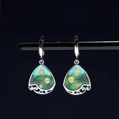 100% handmade sterling silver earrings, covered with hot cloisonné enamel. Cloisonné  is an ancient technique for decorating metalwork objects with colored material held in place or separated by metal strips or wire, normally of gold or silver. This process is quite laborious, because all the details require hand processing. Georgian cloisonné enamel counts more than 1200 years of history.  Our handmade pendants, earrings, brooches are vibrant with colour and compliment any outfit, prefered for daily wear or a special occasion. Materials: Sterling Silver, Fine Silver, Cloisonne enamel Weight - 6 gr (approx) Drop Lenght - 2.2 cm; 0.9 inches  Lenght - 3.5 cm; 1.4 inches Width - 1.8 cm; 0.7 inches  Matching Pendant: https://www.etsy.com/listing/1311367379/georgian-cloisonne-enamel-pendant?cli Green Dangle Earrings, Cloisonne Earrings, Cloisonne Enamel, Jewelry Sterling Silver, Metal Clay, Jewelry Tools, Enamel Jewelry, Silver Foil, Handmade Sterling Silver