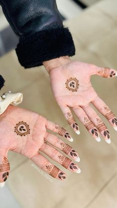 two hands with henna tattoos on them