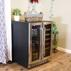 a stainless steel refrigerator with its door open on the floor next to a potted plant