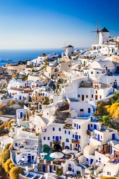 an aerial view of the white buildings and windmills in oia, paros