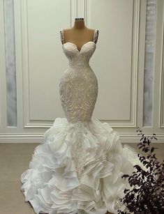 a white wedding dress with ruffles on the skirt