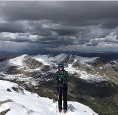 a person standing on top of a snow covered mountain