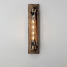 a wall light that is on the side of a wall with two bulbs in it