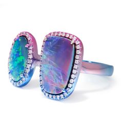 Description: This striking ring by jewelry design house Ruchi, located in New York, features two slices of rare opal with distinctive fire and multi-color rainbow hues. The opals are surrounded by natural brilliant diamonds and are spaced apart allowing the wearer more flexibility for ring sizes ranging from 6.5 to 7.5. The ring is made of solid 18kt gold and features tinted rhodium plating in ombre shades of pink, purple, and blue, uniquely complimenting the opals. This Toi Et Moi ring is Brand New. Specs: Material info: Solid 18Kt (750) Gold with Tinted Rhodium in Ombre Shades of Pink, Purple, and BlueTotal Gram Weight: 7.0 GramsDesigner: RuchiCollection: Aurora Gemstone Information: 1 Oval & 1 Rectangular Cushion Cabochon Cut 4-Prong Set Natural OpalsColor: Multi-Color with FireCut: Ova Luxury Opal Rings With Gemstone Accents, Fine Jewelry Multicolor Multi-stone Opal Ring, Multicolor Opal Multi-stone Rings, Multicolor Opal Gemstone Ring, Multicolor Opal Ring, Rectangular Cushion, Color Rainbow, Ring Sizes, Brilliant Diamond