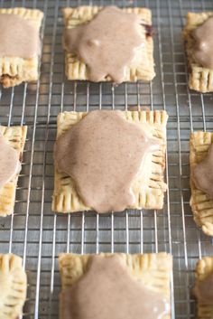 several small pastries on a cooling rack covered in chocolate icing and drizzled with peanut butter