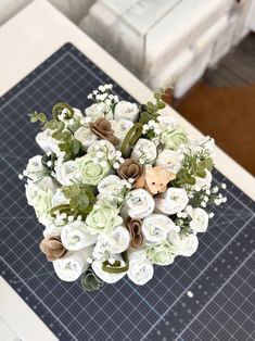 a bouquet of flowers sitting on top of a table next to a piece of paper