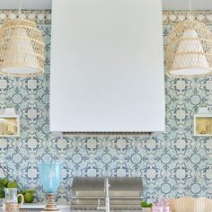 a kitchen with blue and white wallpaper, wicker hanging from the ceiling and an island in front of it