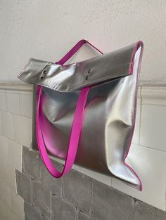 High quality Silver Metallic Leather Tote with Pink Leather Shoulder Strap made of leather from Italy.  Long Pink Handles to fit comfortably over your shoulder. The top fastens gently with Magnets, keeping your valuables secure. While the Smaller Internal Leather Pocket, keeping you organized your small stuff and Items. This Silver Metallic leather has a smooth surface and is tough and durable, leather soft, pleasant to the touch and slightly stretchy. This is a handmade Silver Pink Leather Tote Silver Leather Bags With Leather Handles, Silver Leather Shoulder Bag As Gift, Silver Leather Shoulder Bag For Gift, Silver Bag With Snap Closure For Everyday, Silver Leather Bag With Snap Closure, Silver Bags With Snap Closure For Everyday Use, Silver Bags With Snap Closure, Pink Handles, Small Stuff