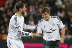 two soccer players shaking hands in front of an audience at a sporting event or competition