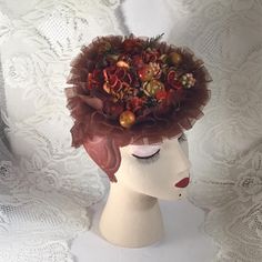 "Vintage 1940's hat. Deep Copper color ruffles with a ringlet in back to help keep the hat in place when worn. Is adorned on the top with fruit (possibly apples), flowers and greens in autumn colors. The hat reminds me of a box of candy. The maker is *Martha Todd* Newark.  *SCROLL DOWN FOR CONDITION & MEASUREMENTS* CONDITION: No issues noted. MEASURES: Front to back~7\" Left to right~7 1/2\" *WE APOLOGIZE~BUT WE CAN NO LONGER SHIP TO GERMANY, ITALY OR SPAIN. IF ORDERS COME IN FROM GERMANY, ITALY OR SPAIN, WE WILL HAVE TO CANCEL THEM AND REFUND YOUR MONEY. SORRY FOR THIS INCONVENIENCE*" 1930s Hat With Faux Fruit, Vintage Pinched Crown Fascinator For Events, Vintage Fascinator With Pinched Crown For Vintage Events, Vintage Fascinator With Pinched Crown For Events, Vintage Hat For Church, Vintage Headpieces For Kentucky Derby And Church, Vintage Curved Brim Headpieces For Kentucky Derby, Vintage Fitted Cloche Headpiece, Vintage Mini Hats With Curved Brim For Costume