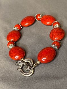 "Heart of Angel, beautiful red porcelain beaded bracelet combined with ash silver bead spacers embracing 8\"round red porcelain beads." Red Bead Bracelet Ideas, Red Oval Beaded Bracelets For Gift, Casual Red Bracelets With Large Beads, Casual Red Jewelry With Large Beads, Casual Red Jewelry With Heart Beads, Red Adjustable Stretch Bracelet With Polished Beads, Casual Red Hand-strung Jewelry, Spiritual Red Bracelets With Silver Beads, Red Spiritual Stretch Bracelet