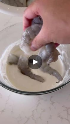 someone is mixing batter in a bowl with two small gray animals on it's side