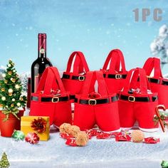 a group of red bags sitting on top of a snow covered ground next to a bottle of wine