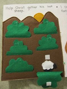 a paper cut out with felt animals and sheep