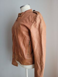 Embrace timeless sophistication with this Cognac Brown Leather Jacket by Zara. Crafted from luxurious sheepskin, this jacket exudes elegance and durability. Featuring two front pockets and a zipped coat design, it offers both style and practicality. The cotton and polyester lining ensures comfort and warmth. Perfect for layering over any outfit, this jacket adds a touch of refinement to your wardrobe. Brand: Zara (Spanish) Condition: used, great vintage. Without damages. Size: L (labeled), large Brown Biker Jacket For Formal Winter Wear, Vintage Leather Jacket With Zipper For Work, Classic Long Sleeve Leather Jacket In Cognac, Classic Cognac Leather Jacket With Long Sleeves, Brown Leather Jacket, Coat Design, Cognac, Brown Leather, Zara