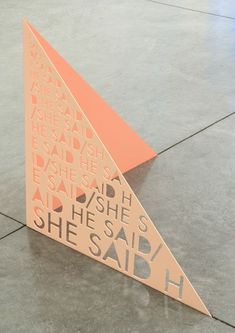 an orange and white paper sculpture on the ground with words written in it that say she said she said