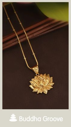 Golden floral pendant necklace displayed against a dark background with the Buddha Groove logo below. Spiritual Gold Plated Flower Pendant Necklace, Spiritual Gold-plated Flower Pendant Necklace, Elegant Brass Necklace With Flower Charm, Elegant Brass Necklaces With Flower Charm, Gold Pendant Necklace For Rituals, Gold Jewelry With Large Pendant For Rituals, Spiritual Gold Necklace With Flower Pendant, Elegant Pendant Jewelry For Puja, 22k Gold Spiritual Pendant Necklace