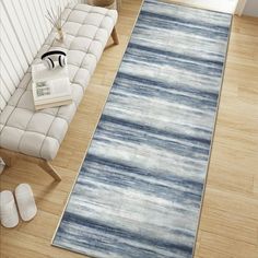 a blue and white area rug on the floor next to a couch in a living room