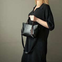 "Black crossbody tote bag small size city style handmade. Mini shoulder bag black color faux leather. Height:18 cm  ( 7,09 \" ) Top Width:29 cm  ( 11,41 \" ) Bottom Width: 21 cm ( 8,26 \" ) Depth:8 cm   ( 3,15 \" ) Strap:115 cm  ( 45,27 \" ) adjustable Black mini tote cross bag made of faux leather. Small black handbag has cotton lining, 3 pockets inside, detachable adjustable strap nylon black. The bag is decorated with a ribbon with a floral pattern. The front of the bag is decorated with two seams, the back of the bag is decorated with a ribbon with a pattern. The bag can be worn both on one side and on one side.  The handbag is decorated with a keychain. Fashion mini black handbag for women. Black small shoulder bag vegan leather handmade. Unique small cross tote bag black vegan leathe Casual Crossbody Satchel With Handles, Black Crossbody Shopping Bag, Black Bucket Bag For Daily Use In Fall, Black Shoulder Bag With Top Carry Handle For On-the-go, Casual Top Handle Shoulder Bag With Adjustable Handle, Trendy Black Crossbody Bucket Bag, Black Shoulder Bag For Fall, Trendy Black Handheld Shoulder Bag, Black Tote Bucket Bag For Fall