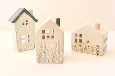 three ceramic houses with flowers painted on them