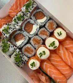 sushi platter with salmon, cucumber and cream cheese on it in a box