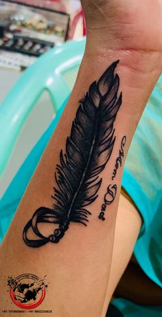 a woman's arm with a tattoo on it that has a black feather and words