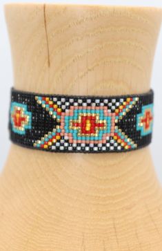 Introducing our southwestern cross cuff bracelet- perfect for adding a touch of boho chic to any outfit! This bracelet is handmade with black leather trim and colorful seed beads, and features an adjustable closure for a perfect fit. It is beaded on strong beading thread & flexible natural leather for comfortable stylish look. It can be worn alone or stacked with other pieces. 7/8 of an inch wide. This bracelet will fit a 6-8 inch wrist. When you purchase this bracelet, I make it to order, just Adjustable Black Cuff Bracelet With Colorful Beads, Southwestern Style Black Beaded Bracelet For Gift, Southwestern Style Black Beaded Bracelet As Gift, Artisan Adjustable Black Cuff Bracelet, Handmade Southwestern Black Beaded Bracelets, Handmade Black Southwestern Beaded Bracelets, Artisan Black Beaded Bracelets With Colorful Beads, Southwestern Black Beaded Bracelet With Colorful Beads, Southwestern Style Black Beaded Bracelet With Colorful Beads