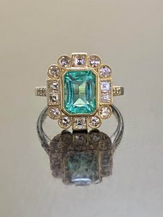 DeKara Designs Classic Handmade Art Deco Oval Emerald and Diamond Ring. Metal- 14K Yellow Gold, .583 Stones- GIA Certified Elongated Octagonal Colombian Emerald 1.99 Carats, 14 Single Cut Round Diamonds G-H Color VS2-SI1 Clarity 0.52 Carats, 6 Square Baguette Diamonds G-H Color VS2-SI1 Clarity 0.50 Carats. GIA Report Number 2225040369 An amazing entirely handmade GIA Certified Elongated Colombian Emerald and Antique Diamond Engagement Ring Created in 14K Yellow Gold. There is a beautiful blue gr Art Deco Green Diamond Ring Hallmarked, Gia Certified Oval Emerald Ring In Art Deco Style, Gia Certified Emerald Cut Art Deco Rings, Luxury Green Diamond Ring Stamped 14k, Heirloom Emerald Ring Stamped 14k, Heirloom 14k Stamped Emerald Ring, 14k Gold Emerald Cut Art Deco Ring, Heirloom Green Diamond Ring With Bezel Setting, Gold Art Deco Ring With Center Stone