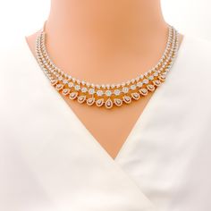 This exquisite 18k gold necklace set, weighing 59.0 grams, features a chic design adorned with dazzling diamonds. The combination of rose and white gold enhances its luxurious appeal, making it perfect for any special occasion. The set includes a necklace with a total diamond weight of 9.97 carats, featuring F-G color and VS quality diamonds in round shapes. The necklace has a length of 17.25 inches with adjustable 0.75-inch links and is secured with a hook lock. The matching earrings, each meas Dazzling Rose Gold Necklace With Cubic Zirconia, Dazzling Rose Gold Diamond Necklace With 17 Jewels, Exquisite Rose Gold Diamond Necklaces, Dazzling Rose Gold Diamond Necklace With Accents, Luxury Jewelry Sets With Elegant Design, Dazzling Rose Gold Diamond Accents Necklace, Dazzling Rose Gold Diamond Necklace, Luxury Diamond Jewelry Sets With Accents, Fine Jewelry Bridal Necklace In Rose Gold And Diamond