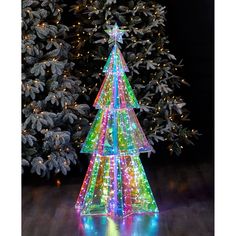 a lighted christmas tree in the middle of a wooden floor