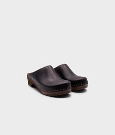 Elevate your everyday style with our minimalist clog mule, featuring clean lines and a timeless aesthetic that effortlessly transitions from day to night. Clog measurements:Heel height: 1 3/4” (4.5 cm)Toe height: 1 5/8″ (4.1 cm) Fit:RegularLeather:Vegetable tanned leather Clogs consist of:Base: European Lime Wood Sole: Rubber sole Fastening: Staples Clog Shoes For Women, Leather Clogs Outfit, Fall Clogs, Clogs Outfit, Black Clogs, Cork Sandals, Wooden Clogs, Timeless Aesthetic, Clog Heels