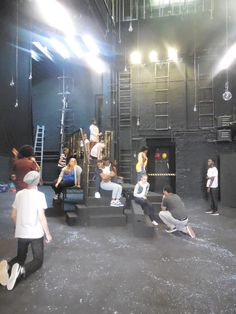 a group of people sitting on top of steps in front of a stage with lights